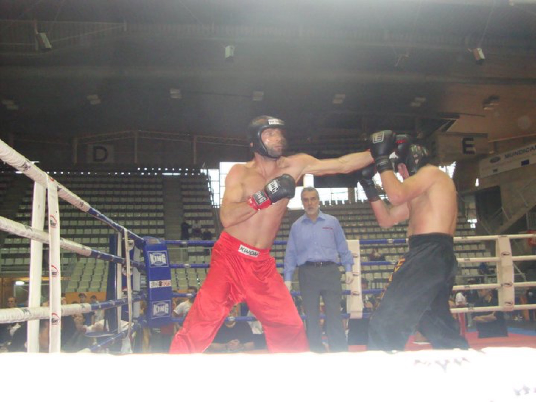 Telat im Kickbox-Wettkampf im Ring, mit Kopfschutz und Handschuhen